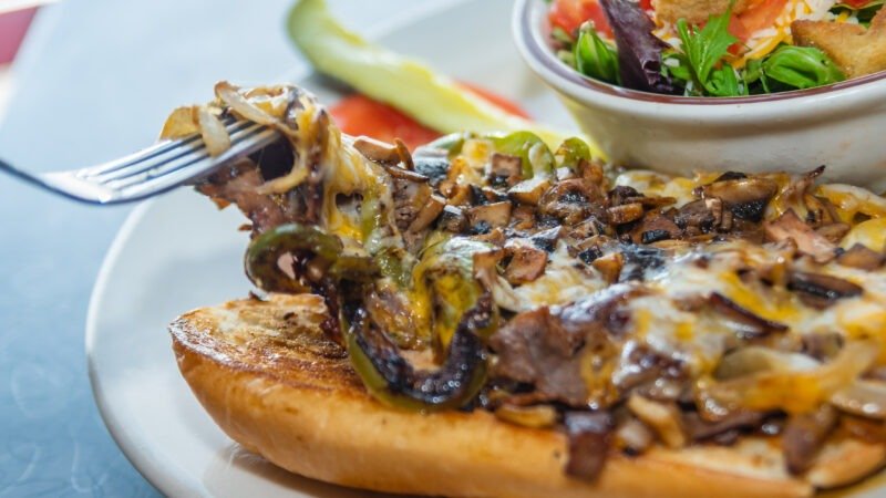 Mouthwatering Philly Cheese Steak sandwich with melted cheese and tender steak at Tasty Munch.