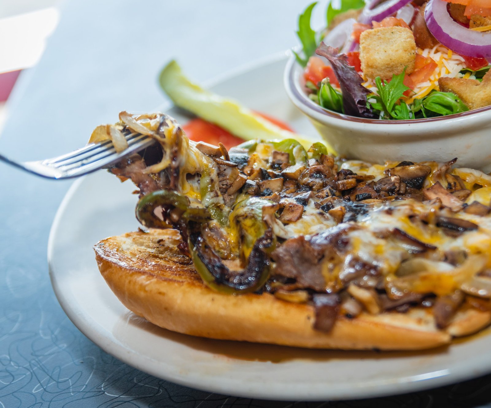 Mouthwatering Philly Cheese Steak sandwich with melted cheese and tender steak at Tasty Munch.