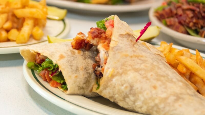 Buffalo Chicken Wrap with shredded lettuce, diced chicken in buffalo sauce, tomatoes, cheddar and jack cheese, and ranch dressing at Tasty Munch.