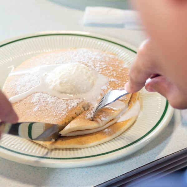 Fluffy Buttermilk Pancakes served with syrup and butter at Tasty Munch.