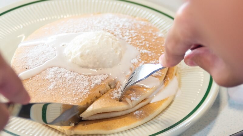 Fluffy Buttermilk Pancakes served with syrup and butter at Tasty Munch.