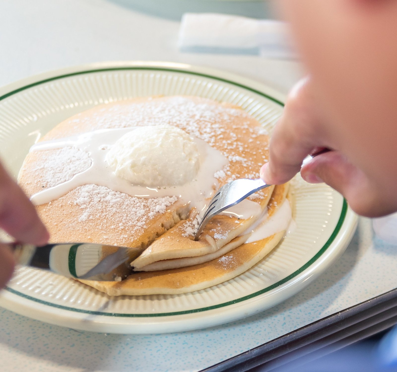 Fluffy Buttermilk Pancakes served with syrup and butter at Tasty Munch.