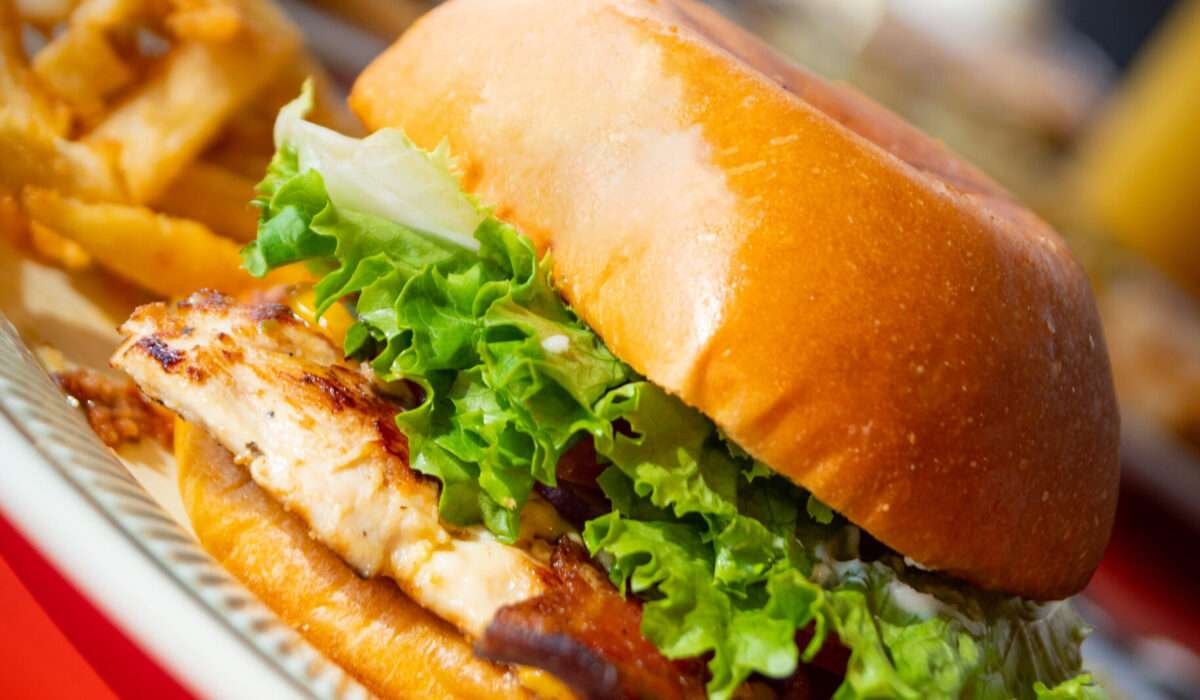 Tasty Chicken Burger with crispy fried chicken, lettuce, and tomato on a bun.