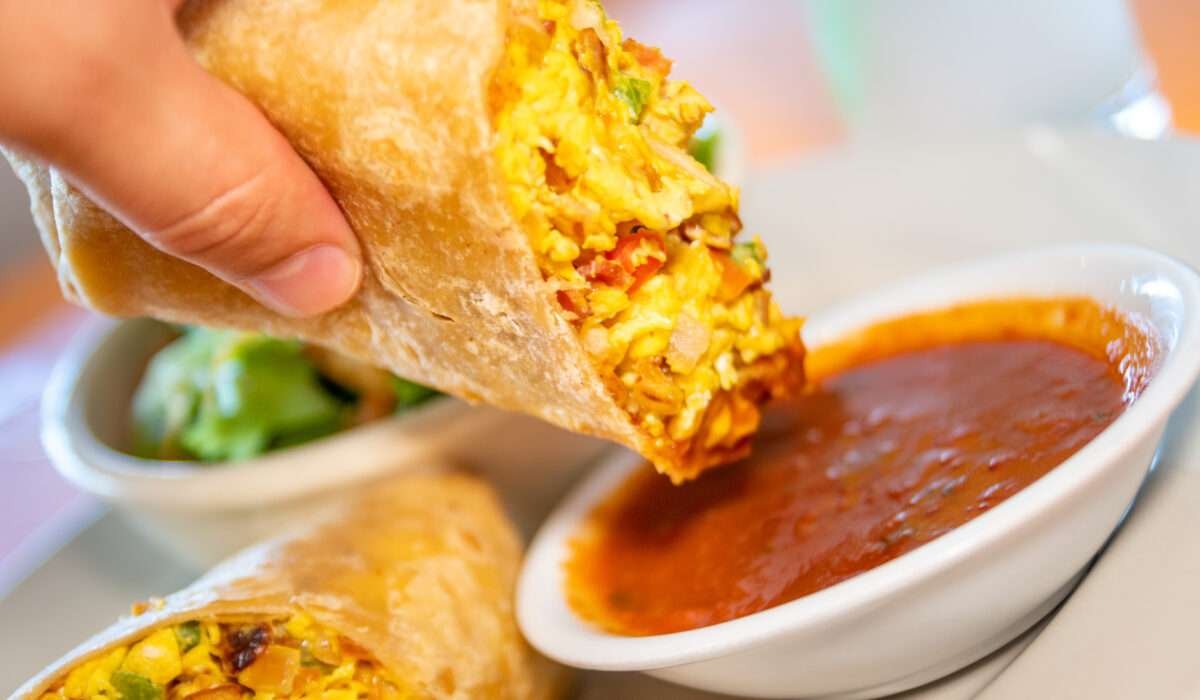 Breakfast burrito with eggs, cheese, and potatoes wrapped in a soft tortilla.
