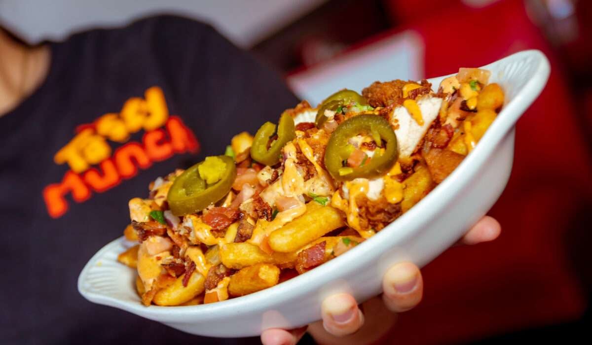 Loaded fries with cheese and chicken served hot at Tasty Munch Houston.